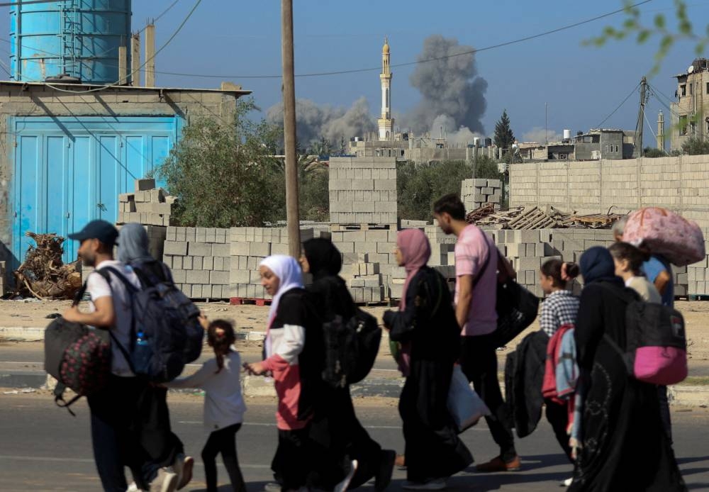 A group of Palestinian civilians walks while evacuating from the north of the Gaza Strip towards south, on Tuesday. REUTERS