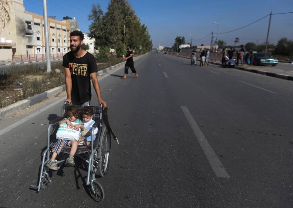 A Palestinian man evacuates with children from the north of the Gaza Strip towards south, on Tuesday. REUTERS