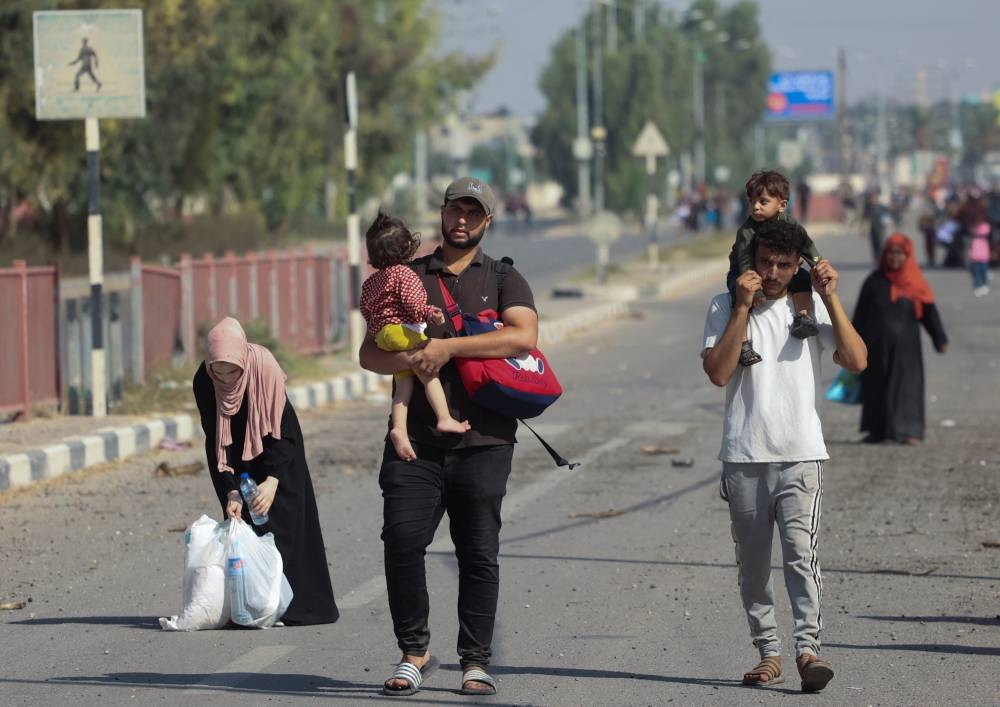 Palestinian civilians walk while evacuating from the north of the Gaza Strip towards south, on Tuesday. REUTERS