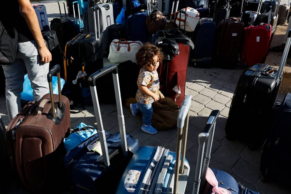A child walks between luggages as Palestinians with foreign passports wait for permission to leave Gaza, at the Rafah border crossing with Egypt, in Rafah in the southern Gaza Strip, on Tuesday. REUTERS