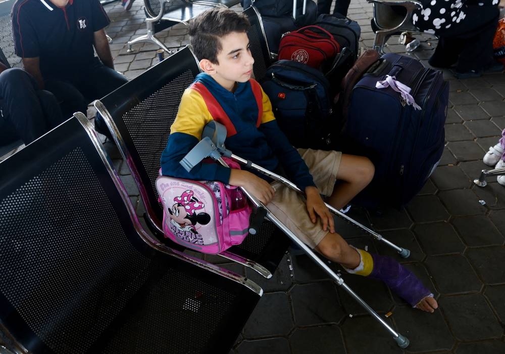 A boy sits as Palestinians with foreign passports wait for permission to leave Gaza, amid the ongoing conflict between Israel and Palestinian Islamist group Hamas, at the Rafah border crossing with Egypt, in Rafah in the southern Gaza Strip, Tuesday. REUTERS