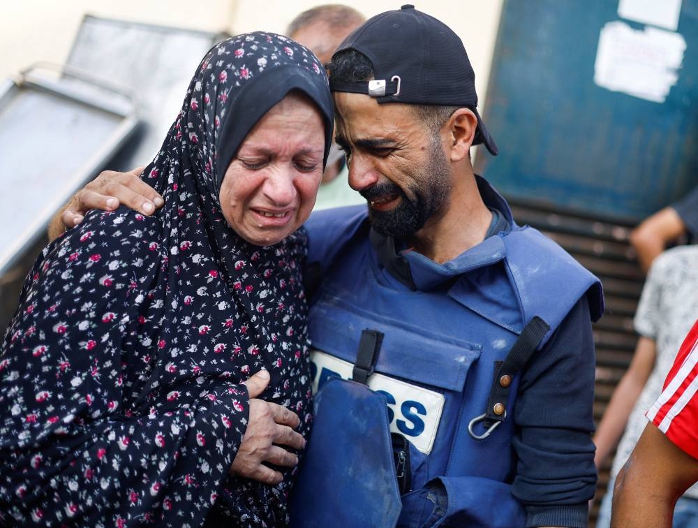 Anadolu news agency cameraman Mohammed El Aloul reacts after several of his children and siblings were killed in Israeli strikes at a hospital in the central Gaza Strip, Sunday. REUTERS