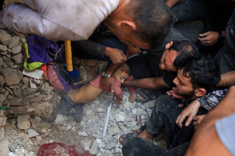 Palestinians pull a child from debris following an Israeli bombardment in Rafah in the southern Gaza Strip on Tuesday. AFP