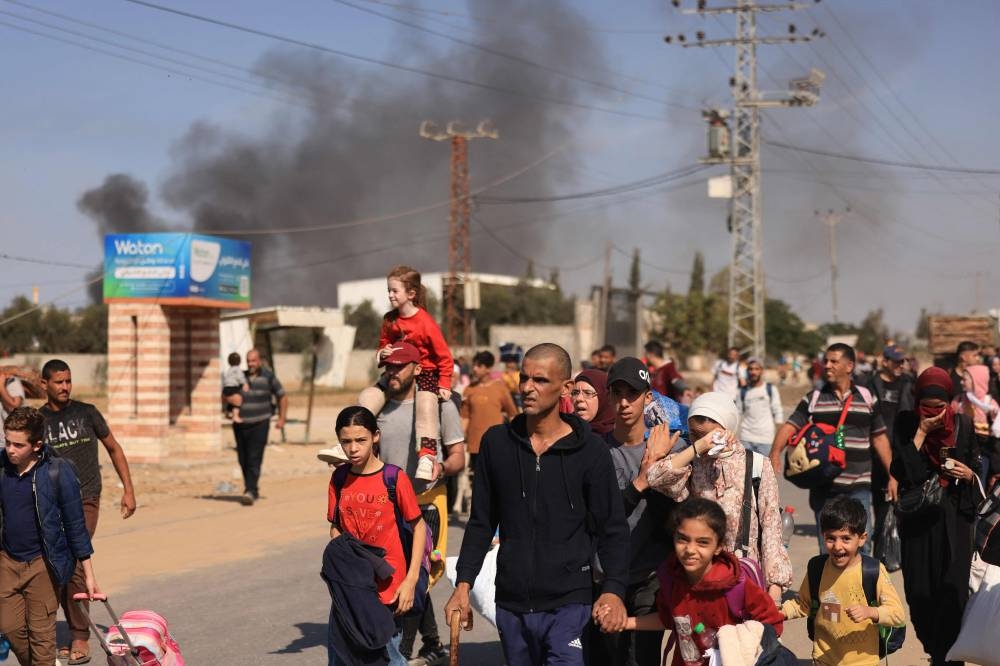 Palestinians families fleeing Gaza City and other parts of northern Gaza towards the southern areas, walk along a road, on Friday. AFP
