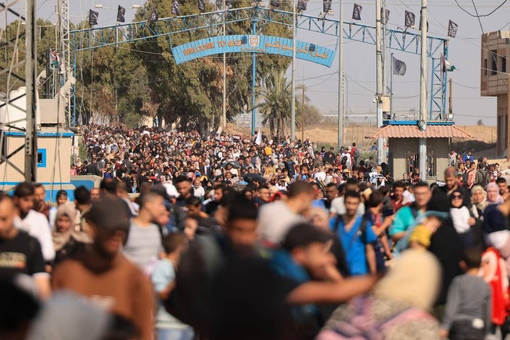 Palestinians families fleeing Gaza City and other parts of northern Gaza towards the southern areas, walk along a road, on Friday. AFP