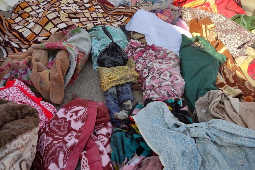 The bodies of people killed in bombardment that hit a school housing displaced Palestinians, lie on the ground in the yard of Al-Shifa hospital in Gaza City, on Friday. AFP
