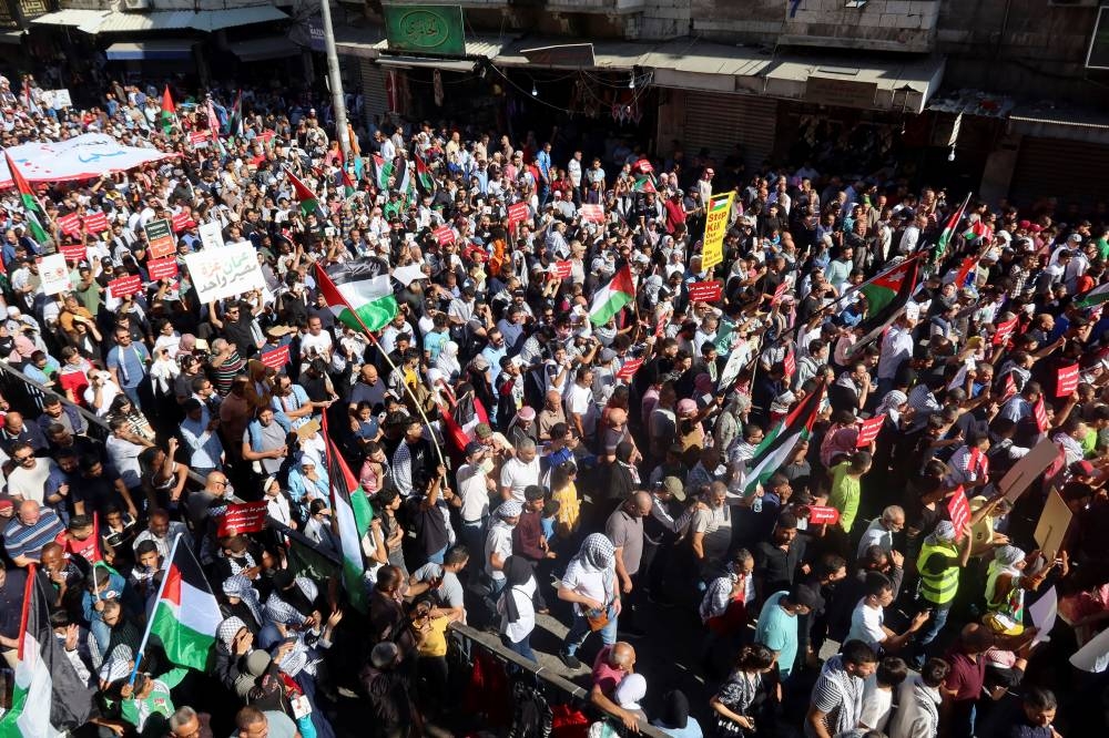 Demonstrators carry flags and banners during a protest in support of Palestinians in Gaza in Amman, Jordan, Friday. REUTERS