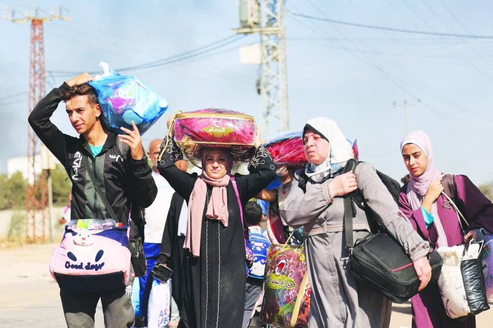 
Palestinian families fleeing Gaza City and other parts of northern Gaza towards the southern areas, walk along a road yesterday. 
