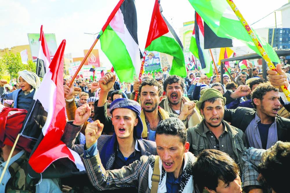 
Yemenis chant slogans and wave flags during a march in solidarity with the people of Gaza, yesterday, in the Houthi-controlled capital of Sanaa. 