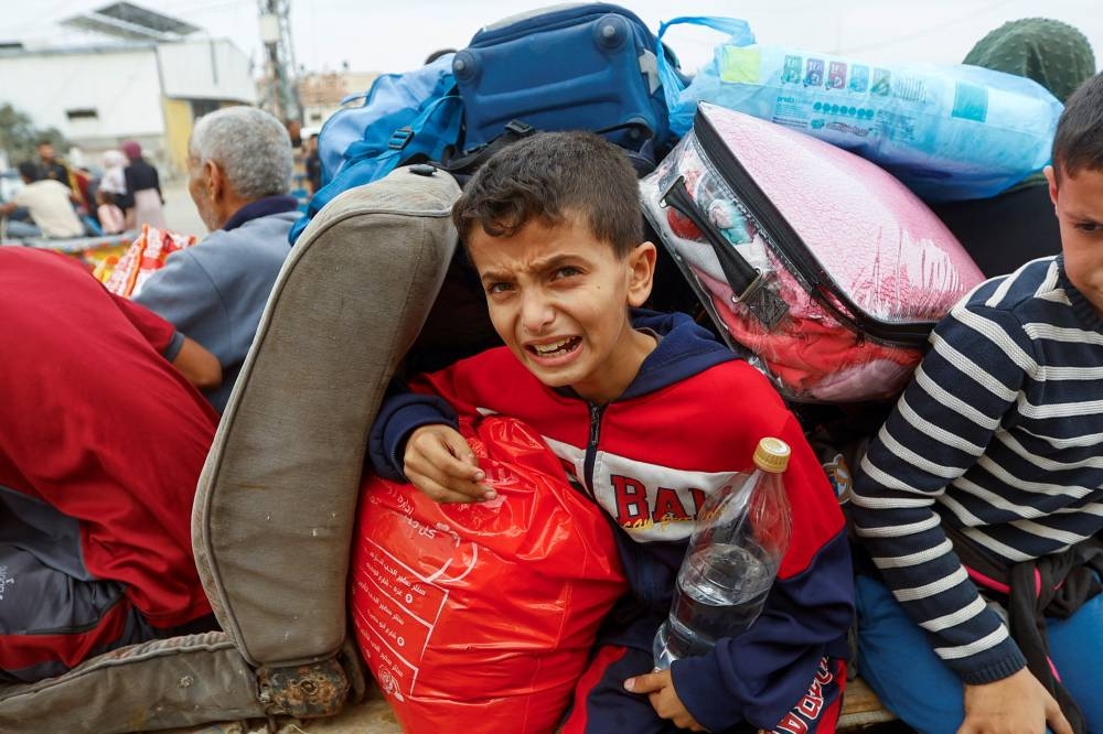 A boy reacts, as Palestinians flee north Gaza to move southward, as Israeli tanks roll deeper into the enclave in the central Gaza Strip, on Sunday. REUTERS