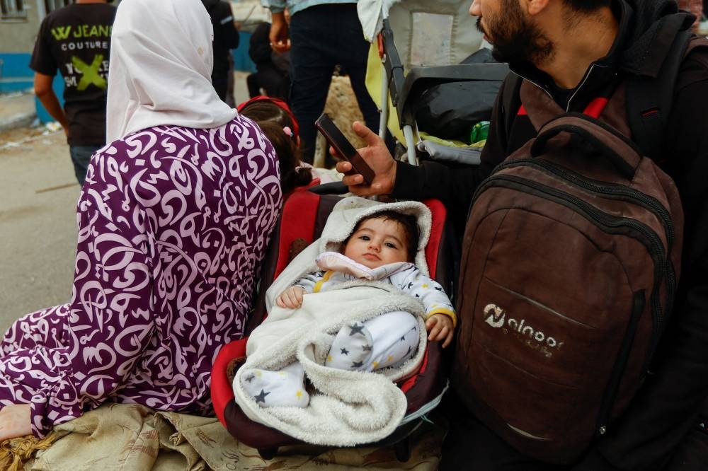 A child looks on as Palestinians flee north Gaza to move southward, as Israeli tanks roll deeper into the enclave, in the central Gaza Strip, on Sunday. REUTERS