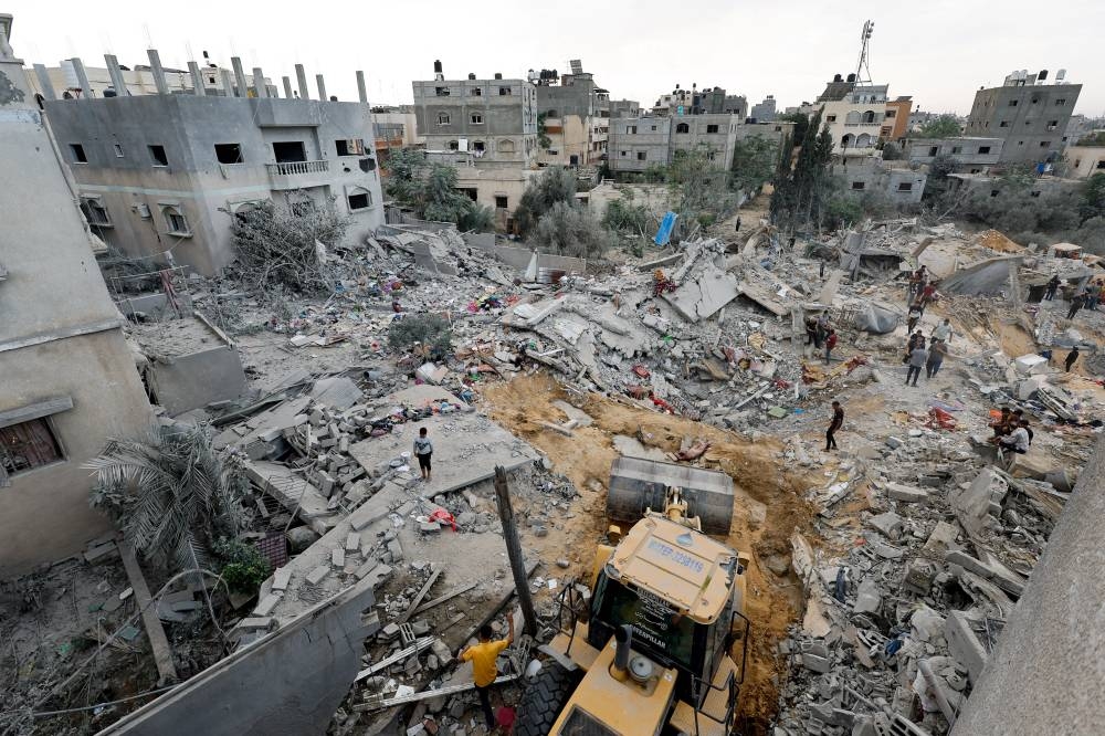 Palestinians gather at the site of an Israeli strike, in Khan Younis in the southern Gaza Strip, on Sunday. REUTERS