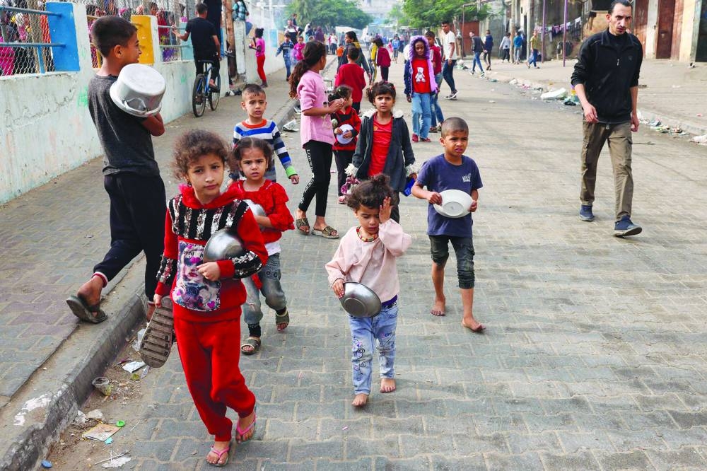 
Displaced Palestinian children gather for breakfast at a refugee camp in Rafah in the southern Gaza Strip, yesterday. 