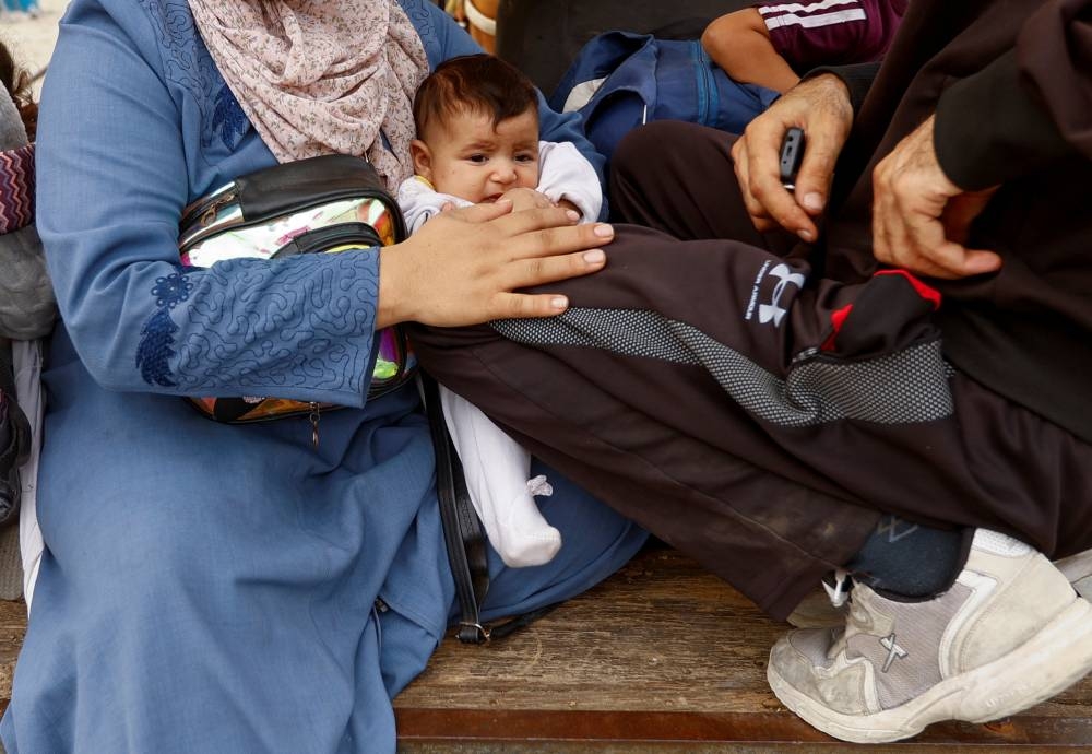 Palestinians fleeing north Gaza ride a horse-drawn cart as they move southward, as Israeli tanks roll deeper into the enclave, in the central Gaza Strip, on Monday. REUTERS