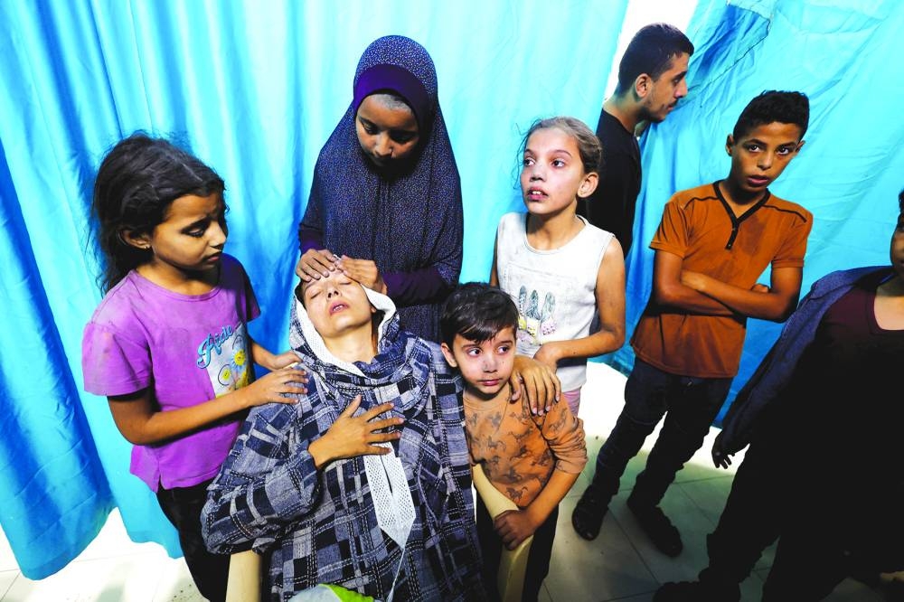 
A Palestinian woman and children react after Israeli strikes, at a hospital in Khan Yunis in the southern Gaza Strip, yesterday. 
