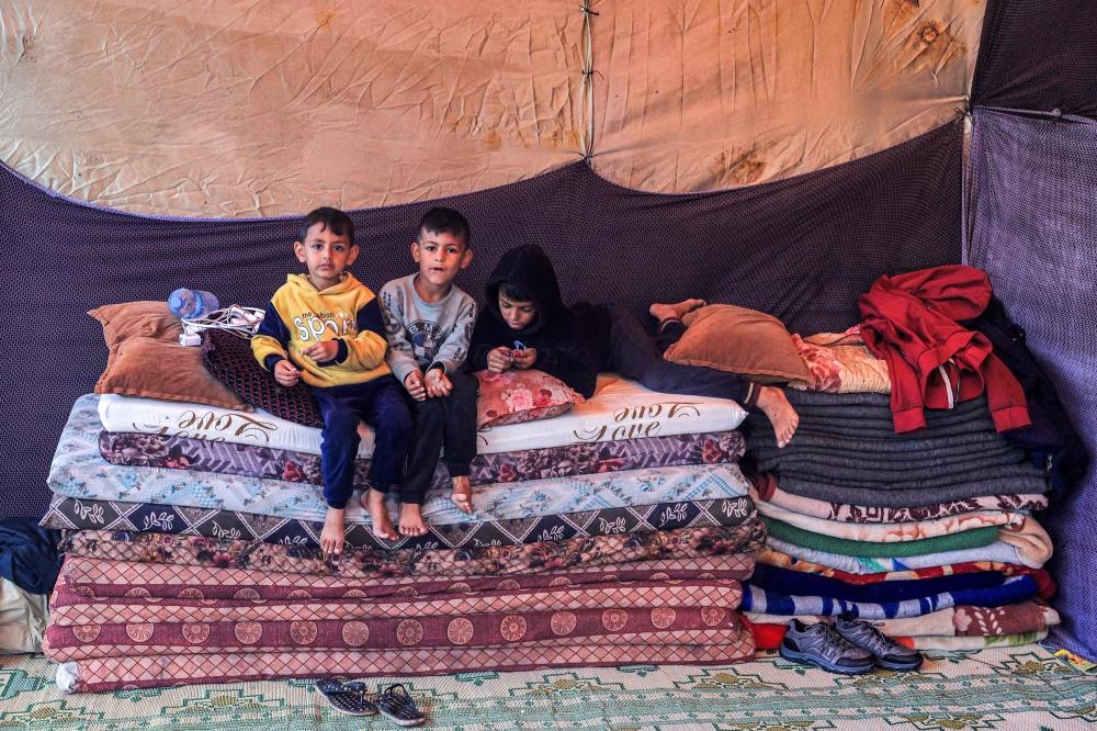 Children sit on mattresses in a shelter at a school run by the United Nations Relief and Works Agency for Palestine Refugees in the Near East (UNRWA) in Rafah in the southern Gaza Strip, on Tuesday. AFP