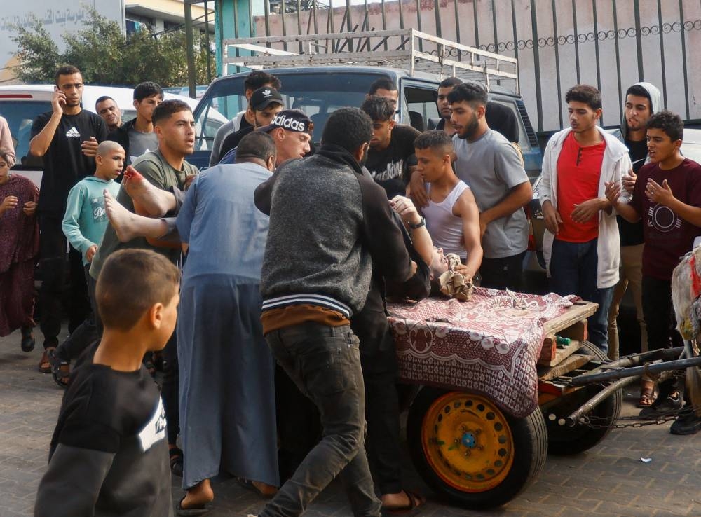 A Palestinian man wounded in an Israeli strike is rushed into Nasser hospital in Khan Younis in the southern Gaza Strip, on Tuesday. REUTERS
