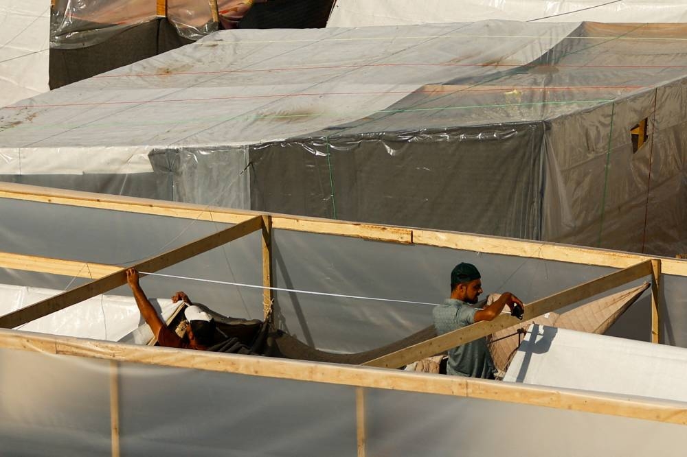 People take measurements at a tent camp sheltering displaced Palestinians in Khan Younis in the southern Gaza Strip, on Tuesday. REUTERS