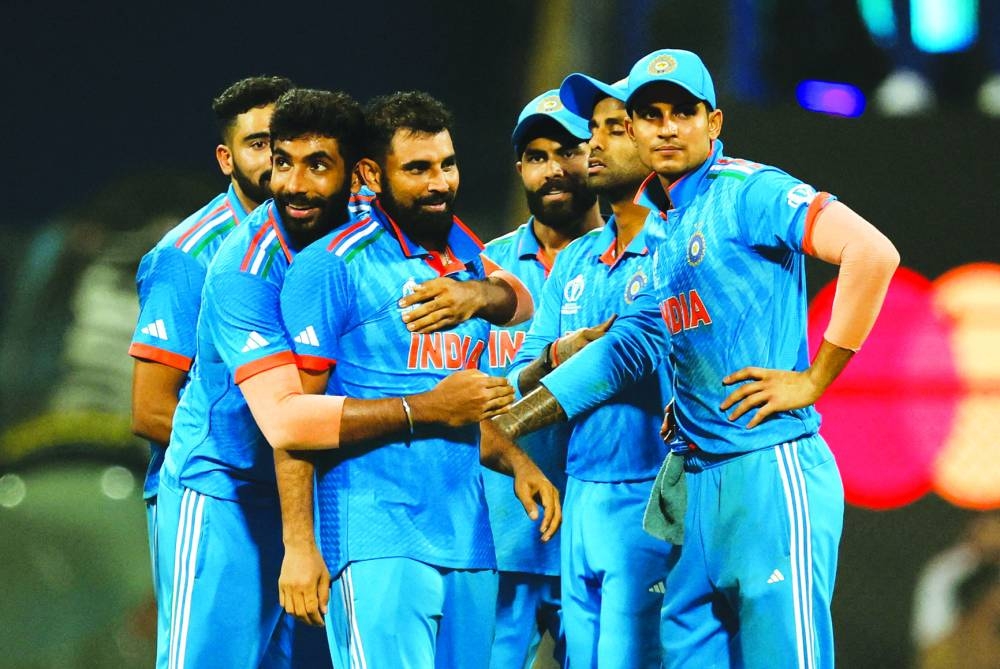 India's Mohamed Shami celebrates with teammates after taking the lbw wicket of New Zealand's Tom Latham in Mumbai yesterday. (Reuters)