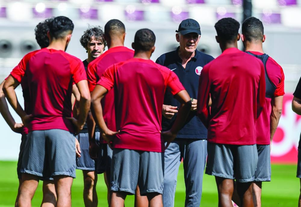 Qatar's head coach Carlos Queiroz talks to his players during a training session at the Khalifa International Stadium yesterday.