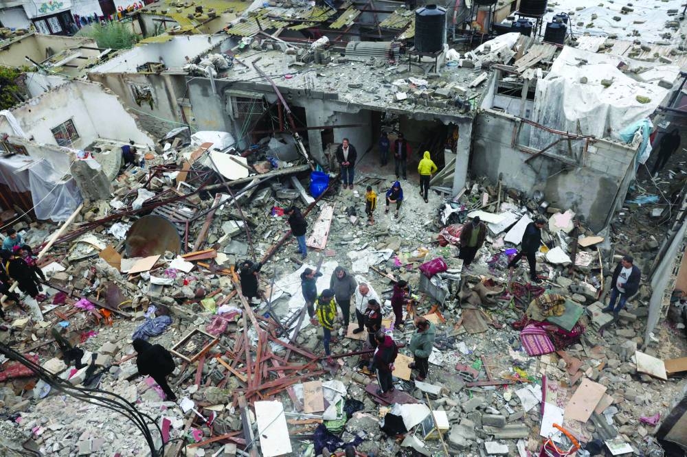 
Palestinians inspect the destruction following the Israeli bombardment of the Rafah refugee camp in the southern Gaza Strip, yesterday. 