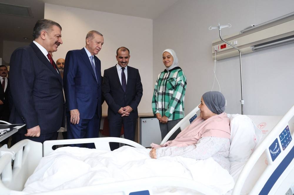  Turkish President Recep Tayyip Erdogan (R) and Turkish Health Minister Fahrettin Koca (L) speak with a Palestinian cancer patient, who had crossed from Gaza into Egypt and brought to Turkey for treatment, at Bilkent City Hospital in Ankara.