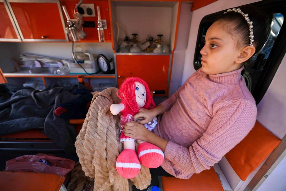 Palestinian children wounded in Israeli strikes wait in an ambulance outside Al-Aqsa hospital in Deir al-Balah in the centre of the Gaza Strip, as they start the process of being evacuated to the United Arab Emirates in a humanitarian flight from al-Arish, in Egypt, on Friday. AFP