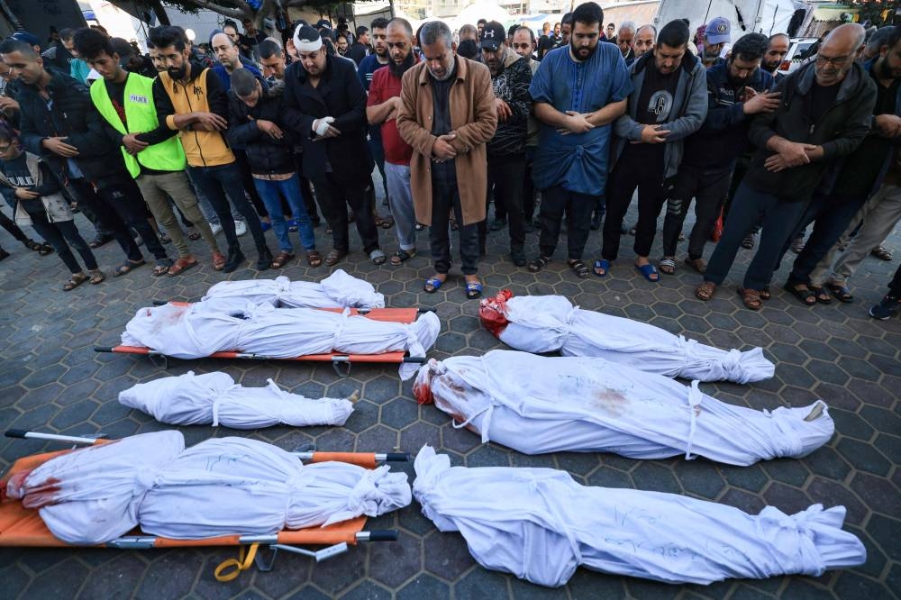 Palestinians mourn over bodies of members of the al-Rifi family who were killed in Israeli bombardment, on Friday outside Al-Aqsa hospital in Deir al-Balah in the centre of the Gaza Strip, on Friday. AFP