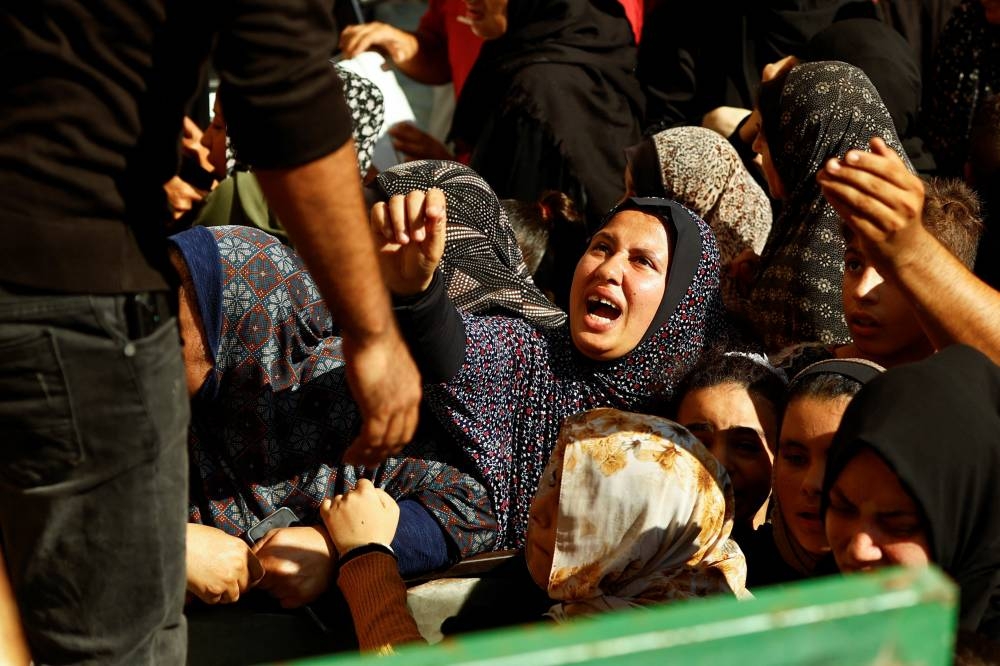 Palestinians queue as they wait to buy bread from a bakery, amid shortages of food supplies and fue, in Khan Younis in the southern Gaza Strip, on Friday. REUTERS