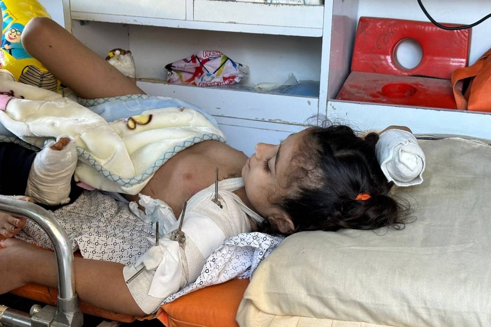 An injured Palestinian child lies in an ambulance on the Egyptian side of the Rafah crossing after being transported from the Gaza Strip, on Friday. AFP