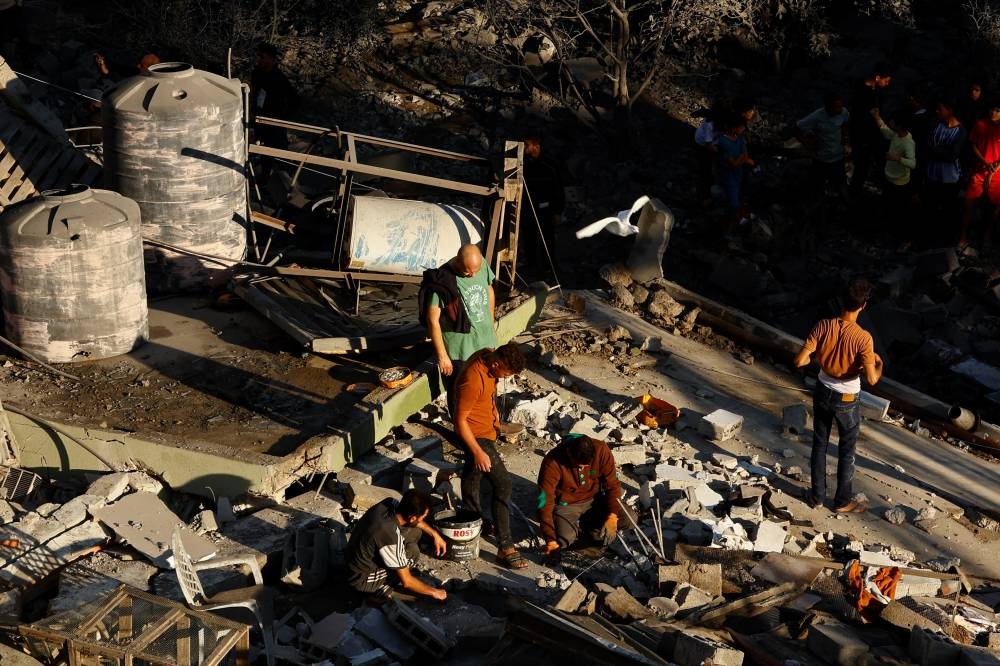 Palestinians gather at the site of an Israeli strike on a house in Khan Younis in the southern Gaza Strip, on Friday. REUTERS