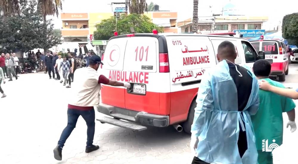 
Injured people are assisted following what Wafa News Agency reports are air strikes by Israeli planes on a residential complex in Deir Al-Balah in the center of Gaza Strip on November 15. Wafa News Agency/via REUTERS