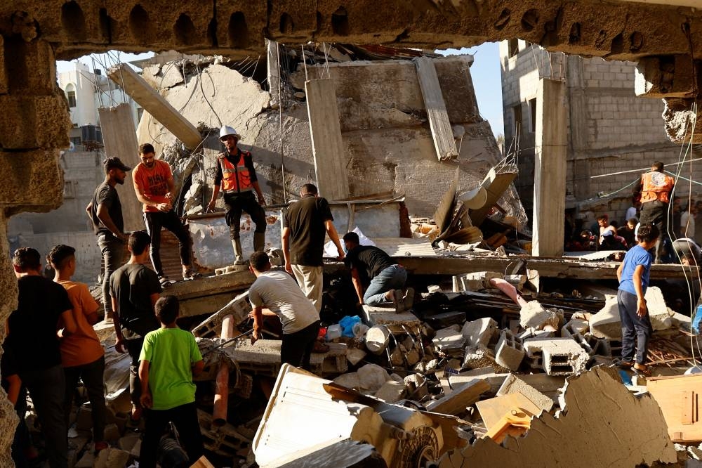 Palestinians search for casualties at the site of an Israeli strike, in Khan Younis in the southern Gaza Strip, on Saturday. REUTERS