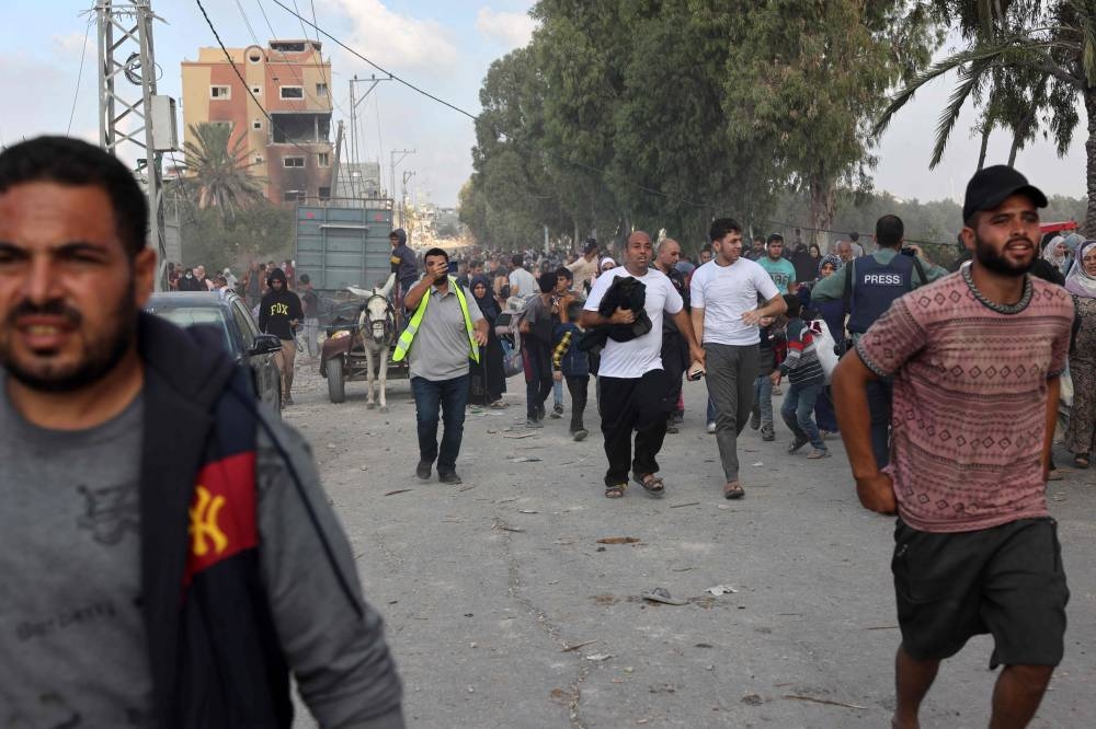 Palestinians walk down a road as they flee Gaza City and other parts of northern Gaza towards the southern areas, on Saturday. AFP