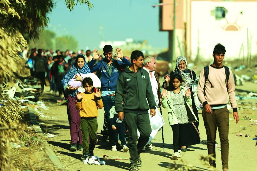 Palestinians fleeing Gaza City and other parts of northern Gaza, carry some belongings as they walk along a road leading to the southern areas of the enclave on November 18, 2023, amid ongoing battles between Israel and the Palestinian Hamas movement. (Photo by MOHAMMED ABED / AFP)
