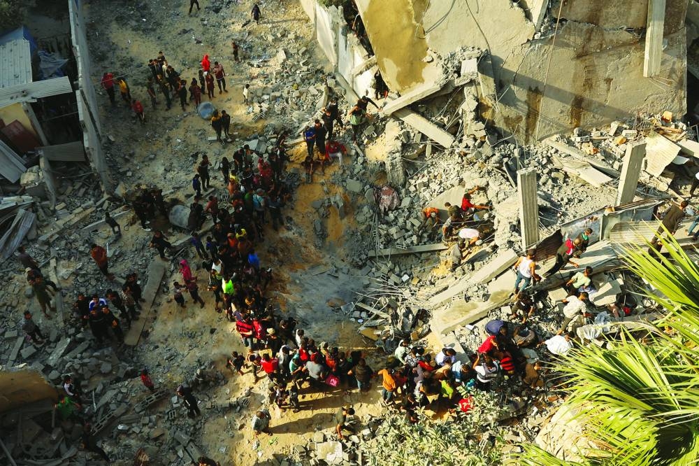 Palestinians gather as others search for casualties at the site of an Israeli strike, amid the ongoing conflict between Israel and Palestinian Islamist group Hamas, in Khan Younis in the southern Gaza Strip November 18, 2023. REUTERS/Ibraheem Abu Mustafa