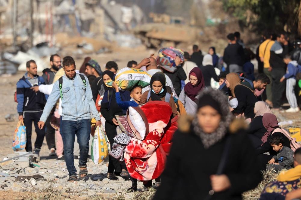 Palestinians fleeing the fighting in war-torn Gaza walk on Salaheddine road in the Zeitoun district of the southern part of the Gaza Strip, on Sunday. AFP