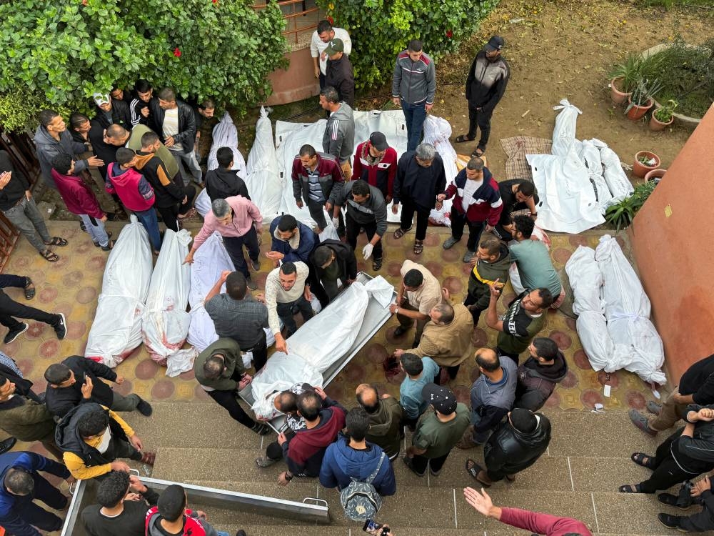 Mourners gather near the bodies of Palestinians killed in Israeli strikes in the southern Gaza Strip, on Sunday. REUTERS