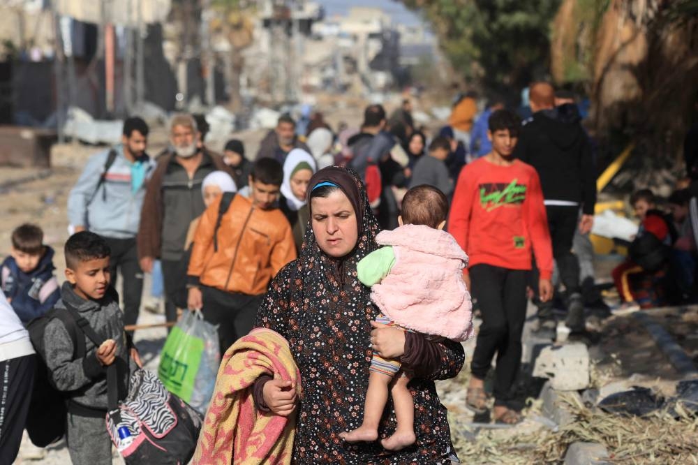 Palestinians fleeing the fighting in war-torn Gaza walk on Salaheddine road in the Zeitoun district of the southern part of the Gaza Strip, on Sunday. AFP