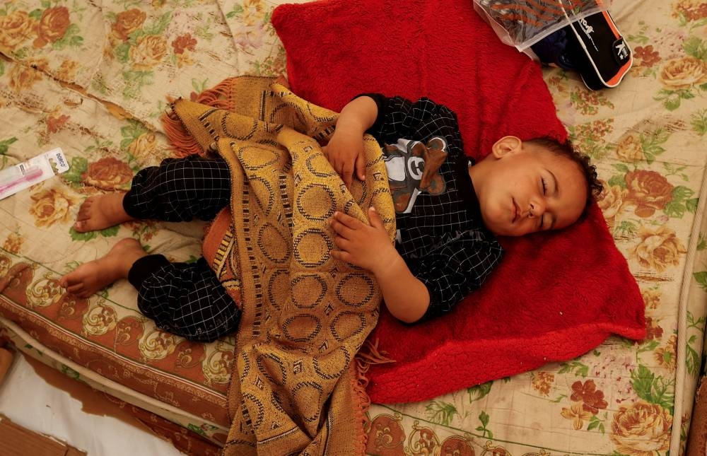 A displaced Palestinian child, who fled his house due to Israeli strikes, sleeps on a bed as he shelters in a tent at Nasser hospital in Khan Younis in the southern Gaza Strip, on Sunday. REUTERS