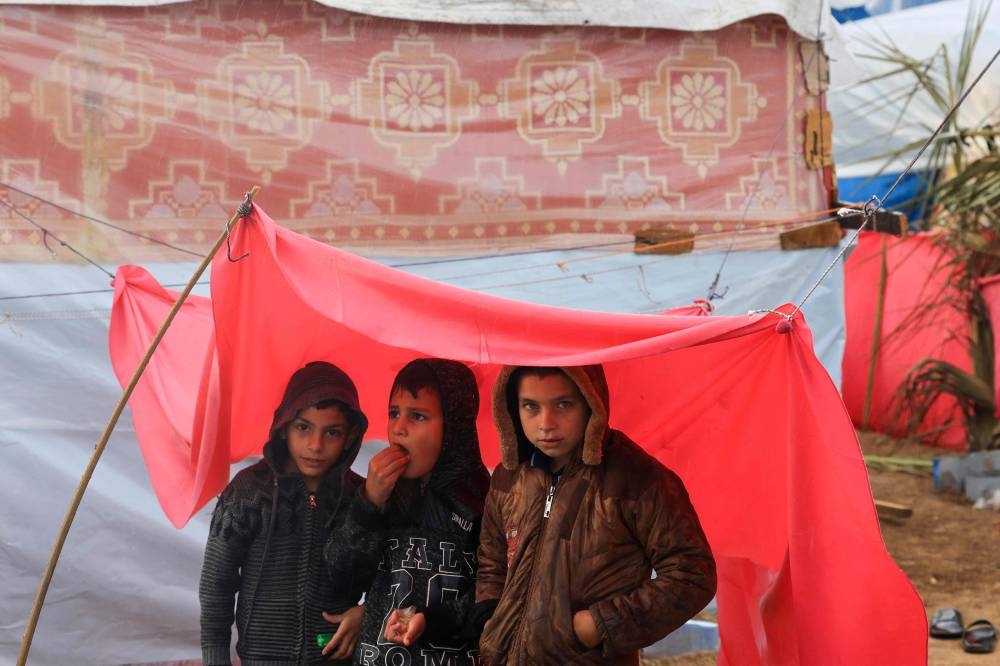 Displaced Palestinian children, who fled the northern Gaza Strip due to Israeli bombardment, stand under a makeshift shelter on the grounds of the Nasser Hospital where they are sheltering in Khan Yunis on the southern Gaza Strip, on Monday. AFP