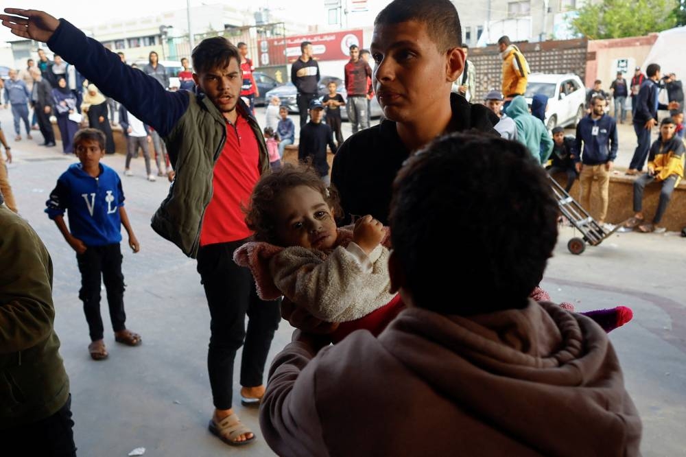 A Palestinian child wounded in an Israeli strike is carried at Nasser hospita in Khan Younis in the southern Gaza Strip, on Monday. REUTERS