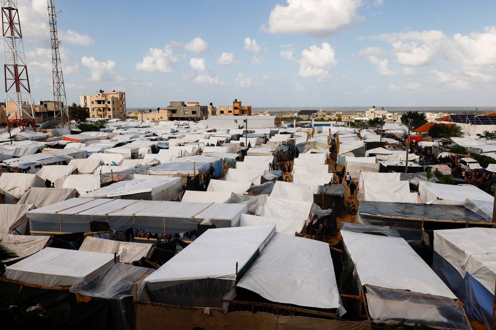 Displaced Palestinian walk among tents in a tent camp in Khan Younis in the southern Gaza Strip, on Monday. REUTERS