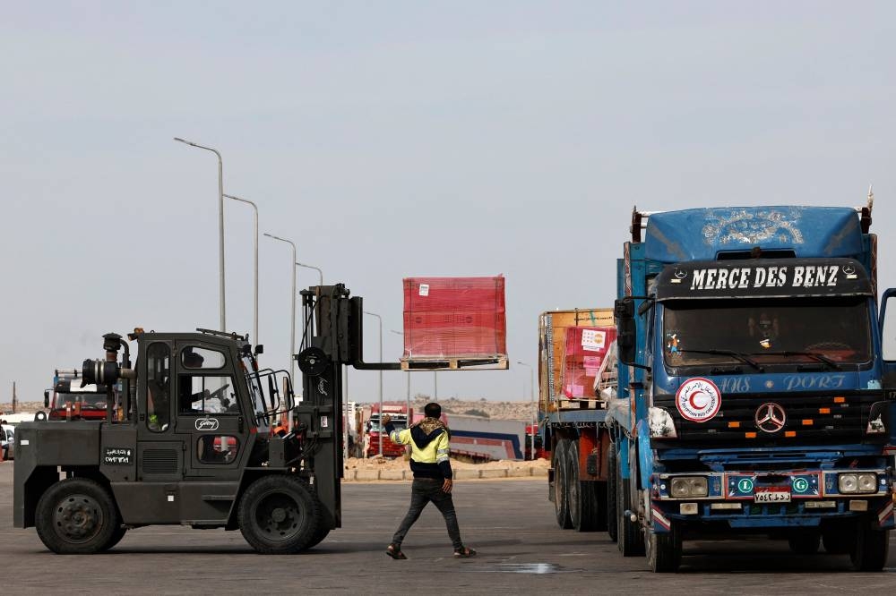 Workers unload humanitarian aid at Egypt's al-Arish Airport on Wednesday, ahead of being transported to the Rafah border area with the Gaza Strip. AFP