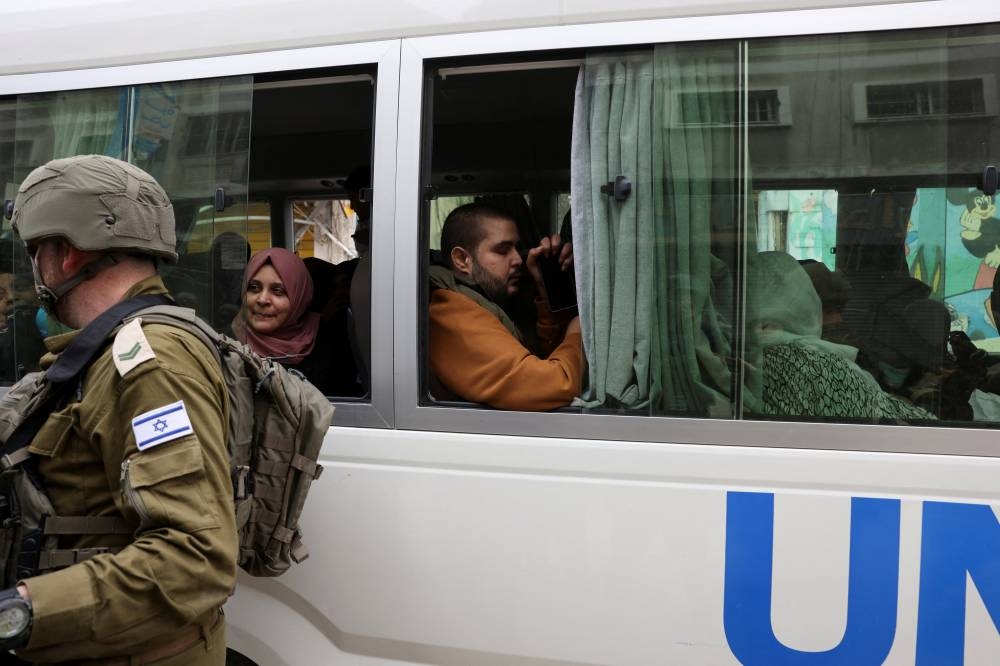 Palestinians sit in a UN bus before leaving the northern Gaza Strip, on Wednesday. REUTERS/Ronen Zvulun