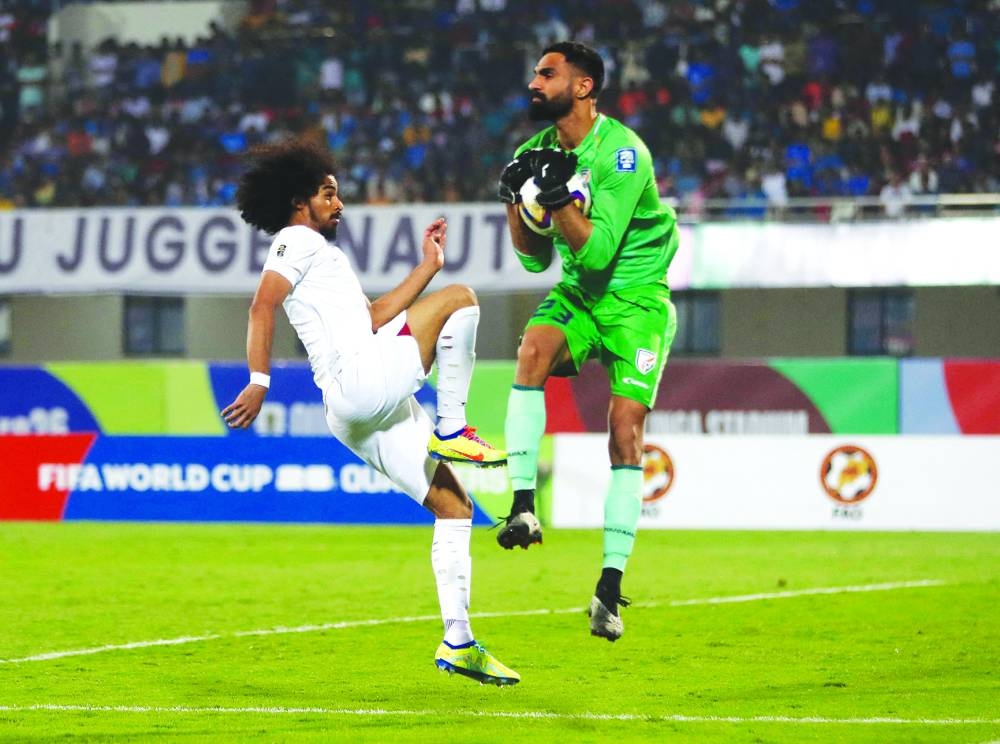 
India’s goalkeeper Amrinder Singh (left) saves a shot off Qatar’s Akram Afif during the World Cup and Asian Cup qualifiers at the Kalinga Stadium in Bhubaneswar, India, on Tuesday. (Reuters) 