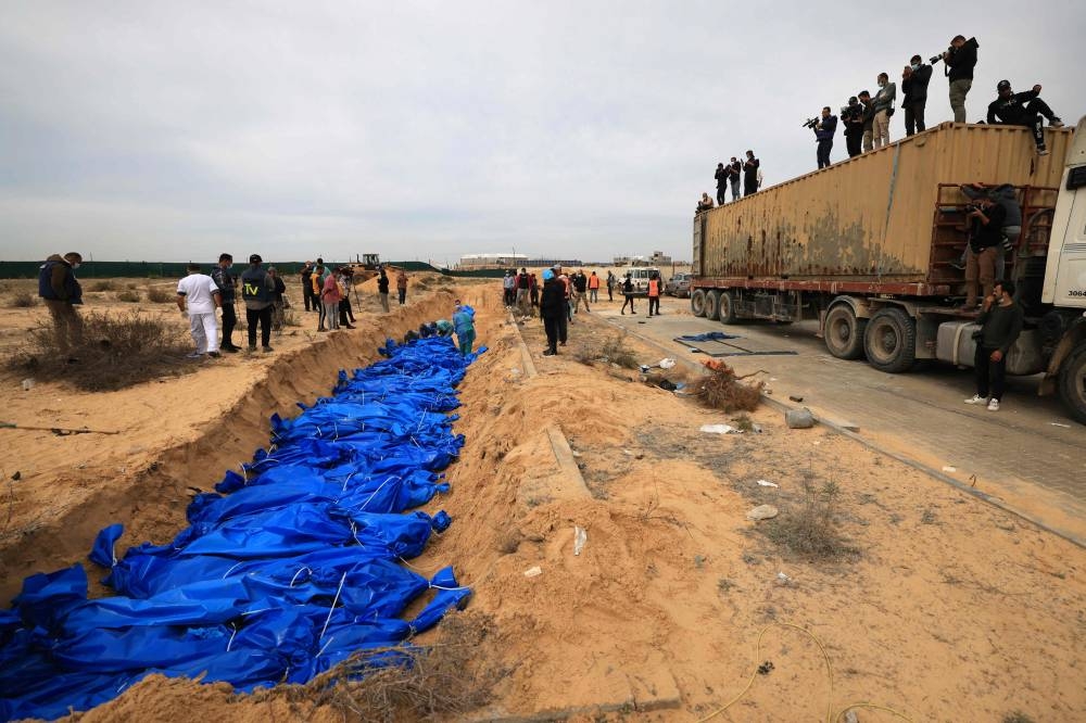 Palestinians bury bodies in a mass grave in Khan Yunis cemetery, in the southern Gaza Strip on Wednesday. AFP