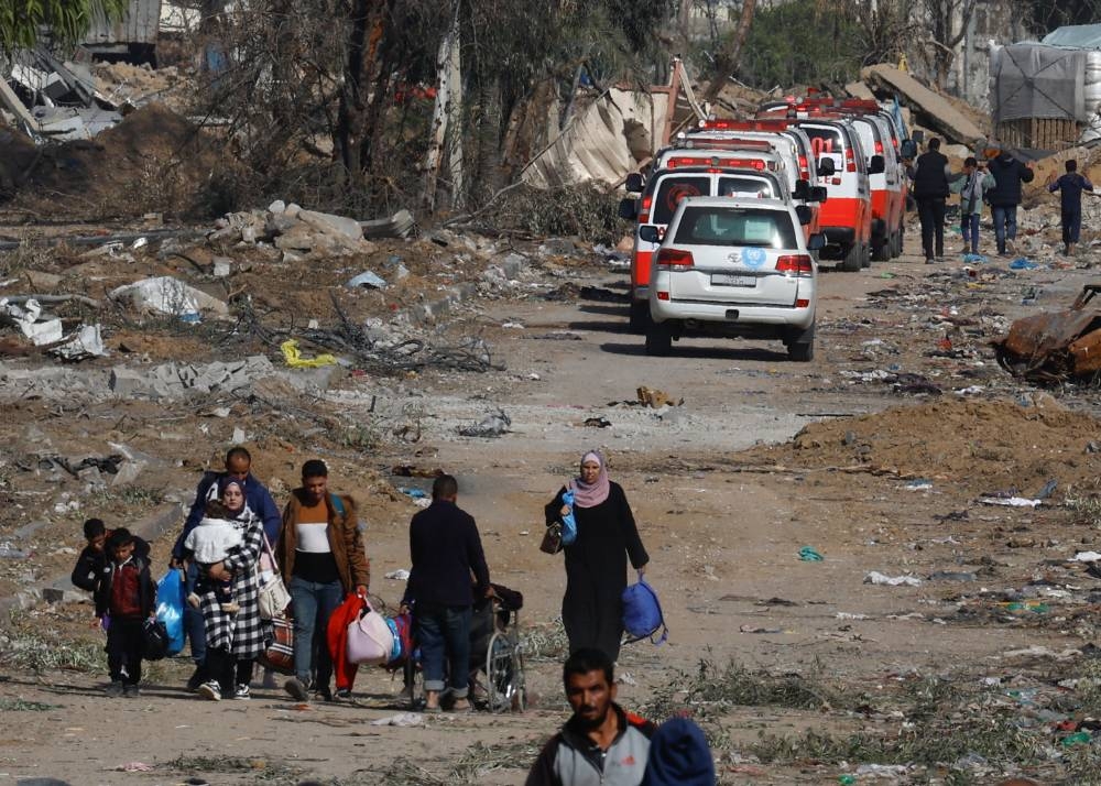 Palestinians flee Gaza City, as a convoy of ambulances heads towards the city, during a temporary truce between Israel and Hamas, near Gaza City on Friday. REUTERS