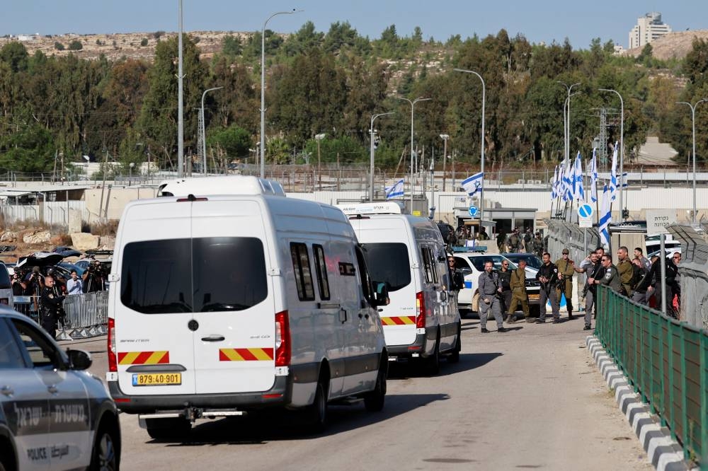 Vans carrying Palestinian prisoners arrive to the Israeli military prison, Ofer, near Ramallah, in the Israeli-occupied West Bank, from another Israeli prison, before they are due to be released as part of a deal between Israel and Hamas, to free hostages held in Gaza in exchange for the release of Palestinian prisoners on Friday. REUTERS