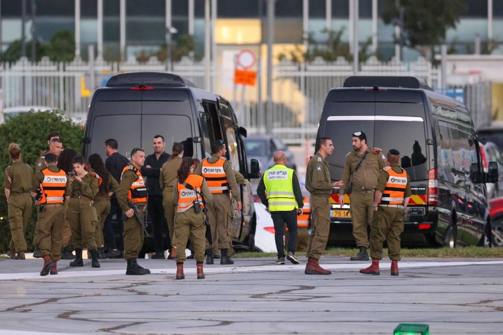 Israeli security forces stand next to buses waiting at the helipad of Tel Aviv's Schneider medical centre Friday, amid preparations for the release of Israeli hostages held by Hamas in Gaza in exchange for Palestinian prisoners later in the day. AFP